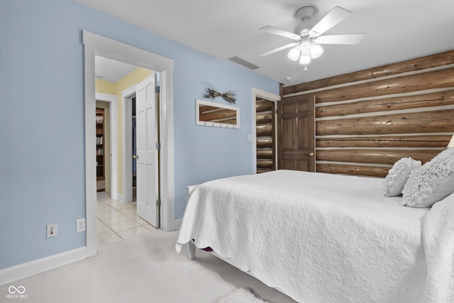 bedroom with ceiling fan, rustic walls, and light colored carpet