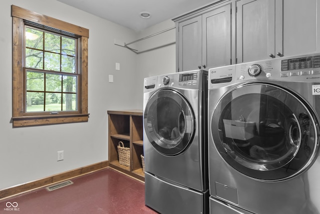 washroom featuring cabinets and washing machine and clothes dryer