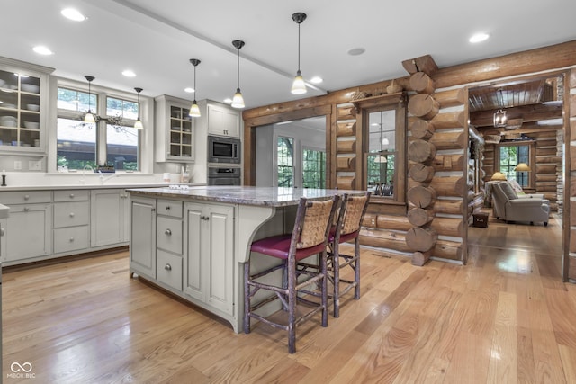 kitchen featuring a kitchen island, appliances with stainless steel finishes, gray cabinetry, and decorative light fixtures