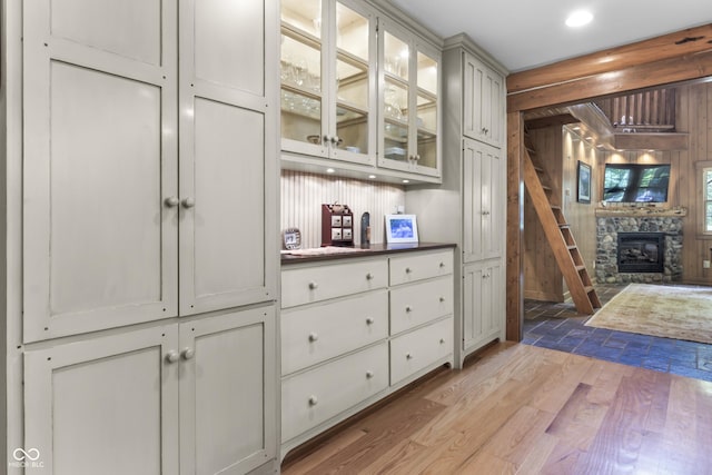 interior space featuring wooden walls, a fireplace, and light wood-type flooring