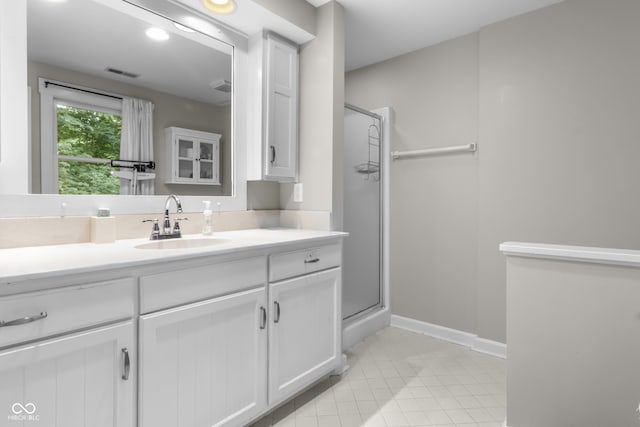 bathroom featuring vanity, tile patterned floors, and walk in shower