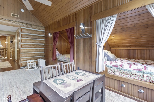 bedroom featuring high vaulted ceiling, log walls, and wooden walls