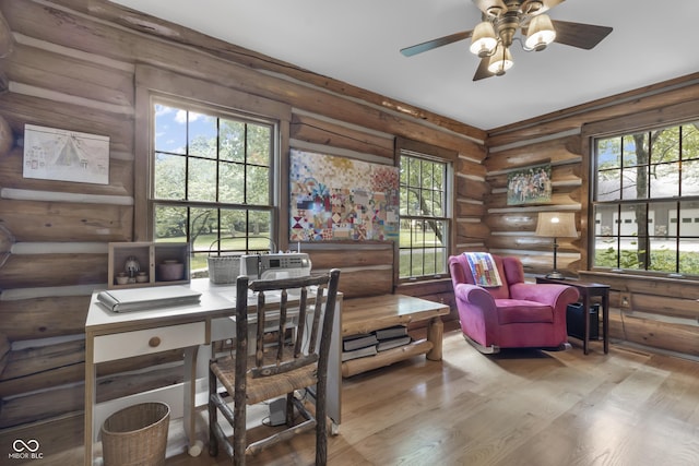 office featuring ceiling fan, log walls, and light wood-type flooring