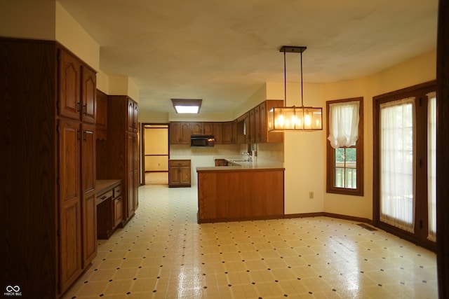 kitchen with hanging light fixtures, sink, and kitchen peninsula