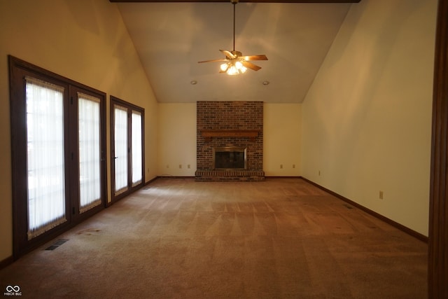 unfurnished living room featuring a fireplace, plenty of natural light, high vaulted ceiling, and carpet