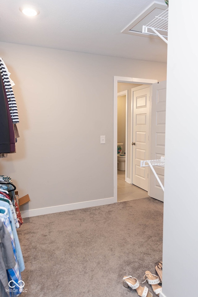 spacious closet featuring light colored carpet