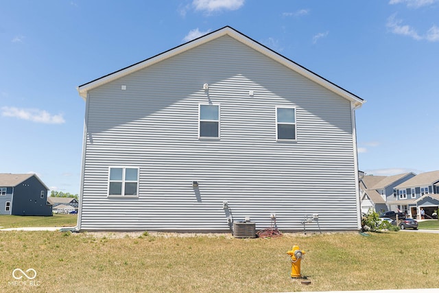 view of side of property featuring a yard and central air condition unit