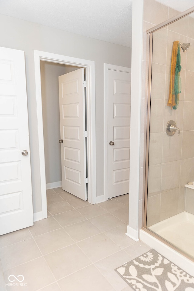 bathroom featuring tile patterned flooring and a shower with shower door