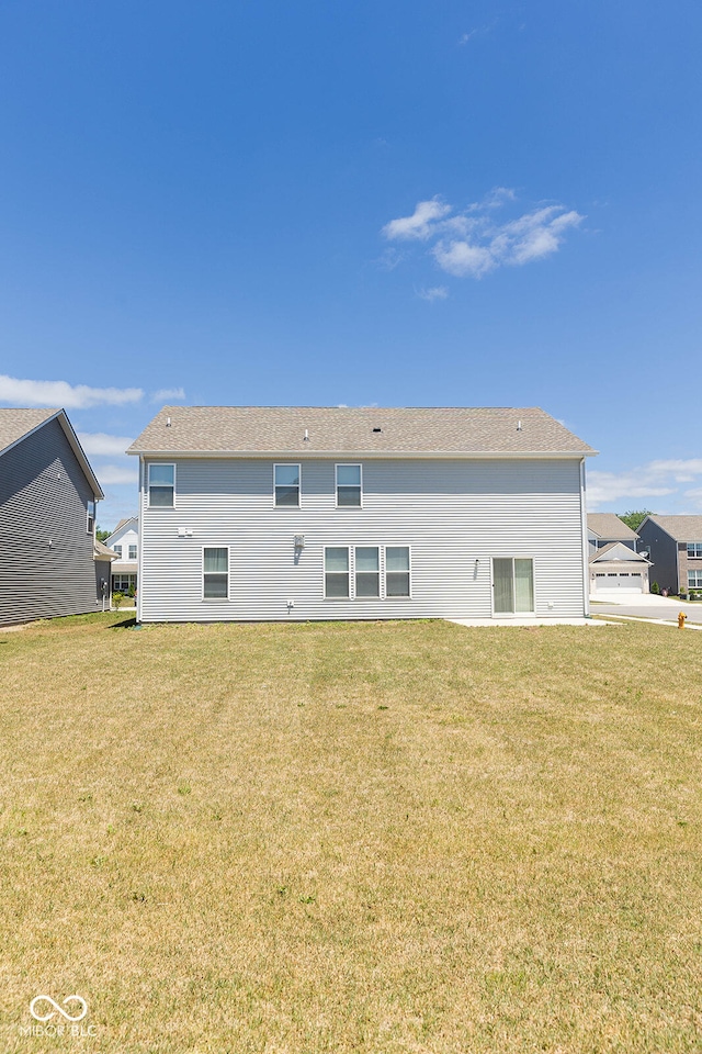 rear view of property featuring a lawn