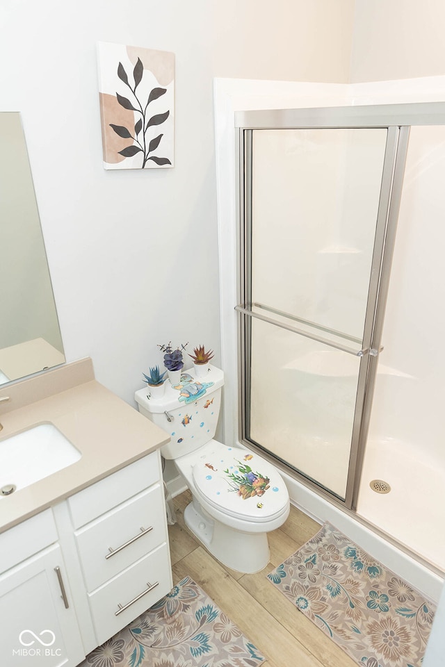 bathroom with vanity, hardwood / wood-style floors, toilet, and an enclosed shower