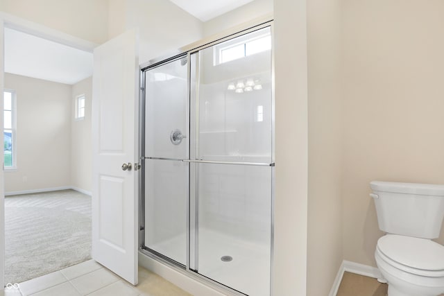 bathroom with toilet, walk in shower, and tile patterned flooring