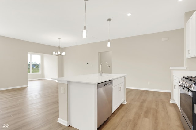 kitchen featuring sink, stainless steel appliances, white cabinetry, and a center island with sink