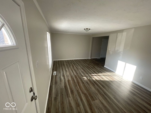 unfurnished room featuring a textured ceiling and dark hardwood / wood-style flooring