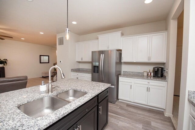 6748 Fallen Leaf Dr, Whitestown, IN 46075 - kitchen featuring stainless steel refrigerator with ice dispenser, a sink, white cabinetry, open floor plan, and pendant lighting