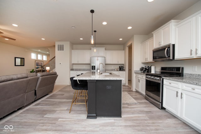 6748 Fallen Leaf Dr, Whitestown, IN 46075 - kitchen featuring appliances with stainless steel finishes, a sink, open floor plan, recessed lighting, and white cabinets