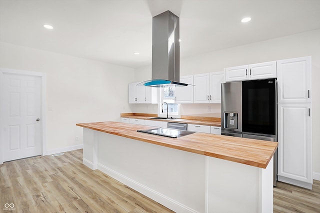 kitchen featuring sink, white cabinets, a kitchen island, island range hood, and butcher block counters