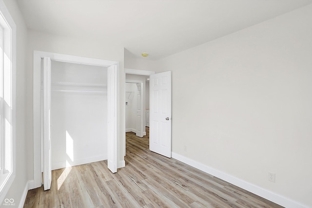 unfurnished bedroom featuring a closet and light wood-type flooring