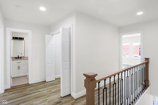 hallway with sink and light hardwood / wood-style flooring