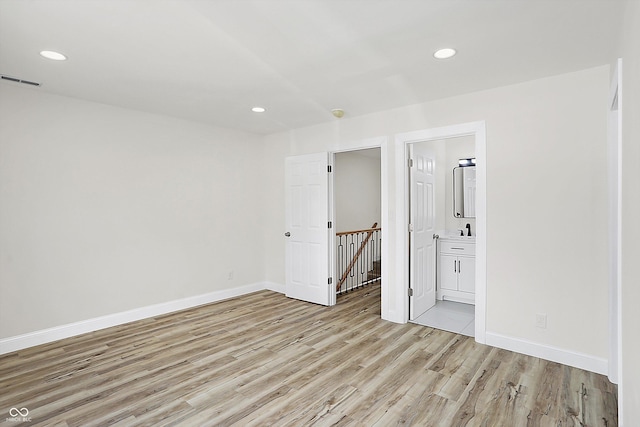 spare room with sink and light hardwood / wood-style flooring