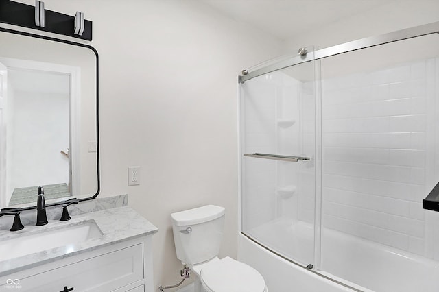 full bathroom featuring toilet, shower / bath combination with glass door, and vanity