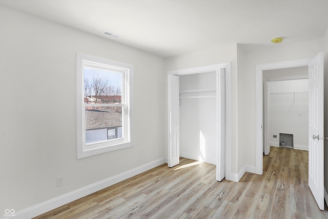 unfurnished bedroom with light hardwood / wood-style flooring and a closet