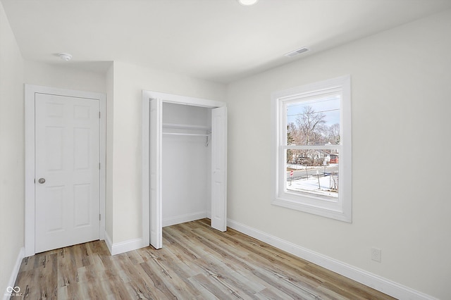 unfurnished bedroom featuring light wood-type flooring and a closet