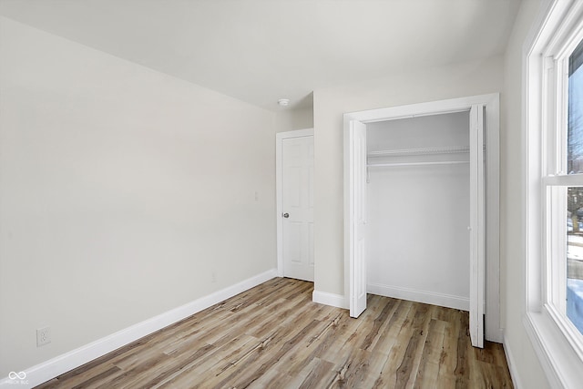 unfurnished bedroom with light hardwood / wood-style floors and a closet