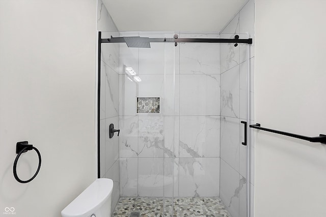 bathroom with toilet and a shower with shower door