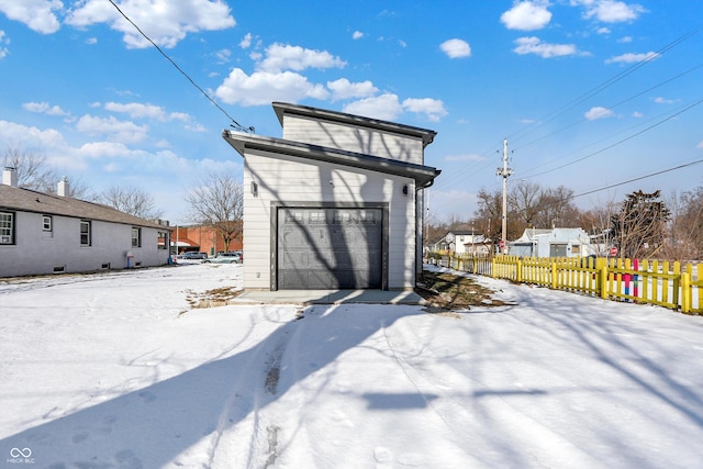 snow covered structure with a garage