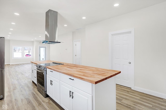 kitchen featuring a center island, appliances with stainless steel finishes, island exhaust hood, wooden counters, and white cabinets