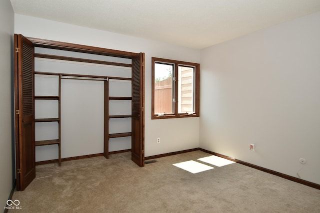 unfurnished bedroom featuring a closet and light carpet