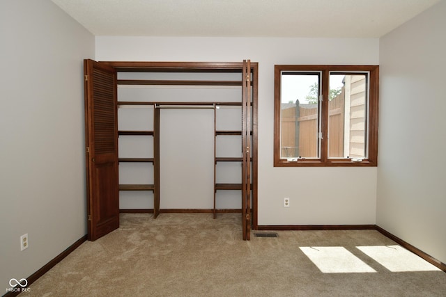 unfurnished room featuring light carpet