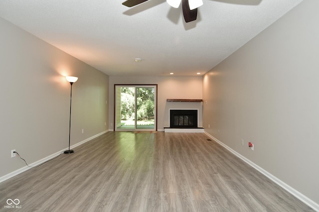 unfurnished living room with ceiling fan and light hardwood / wood-style flooring