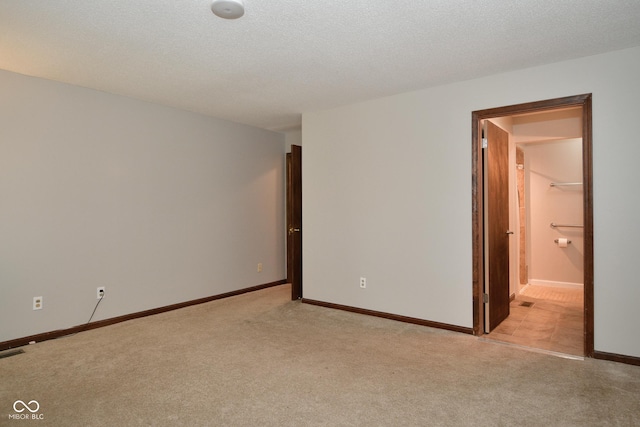 carpeted empty room featuring a textured ceiling