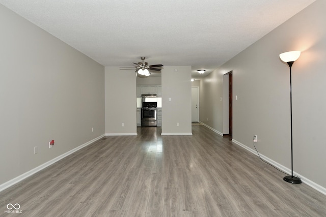 unfurnished living room with a textured ceiling, light hardwood / wood-style flooring, and ceiling fan