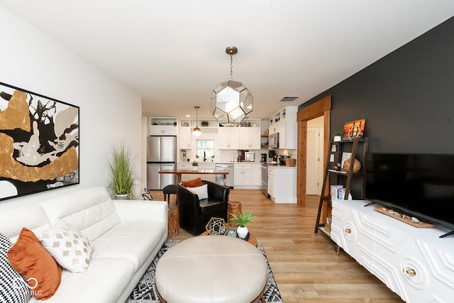 living room featuring sink and light hardwood / wood-style floors