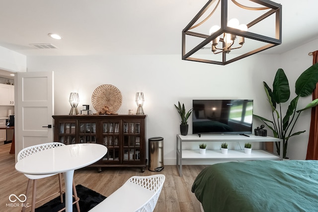 bedroom with hardwood / wood-style flooring and a chandelier