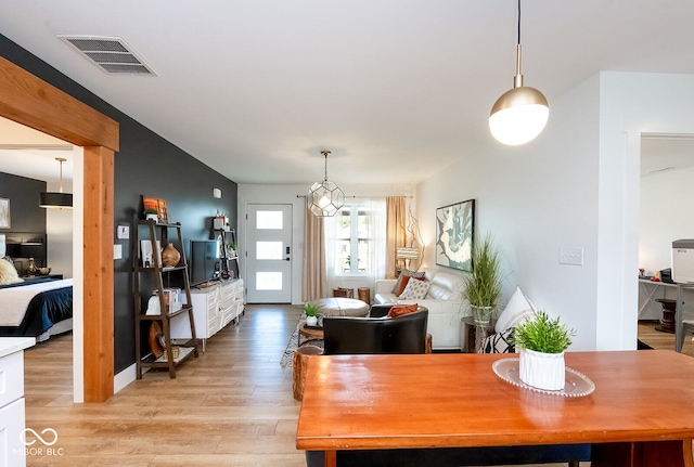 dining area with a notable chandelier and light wood-type flooring