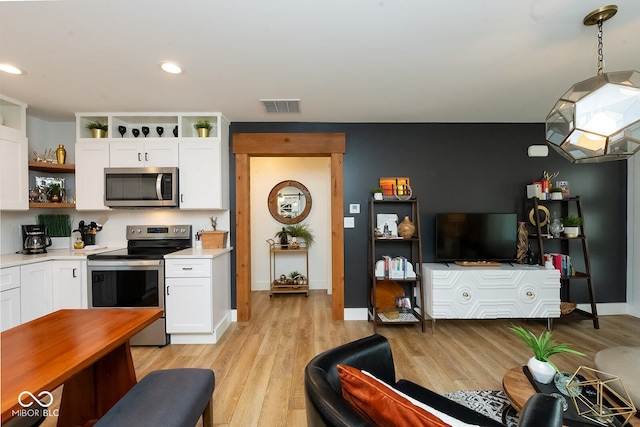 kitchen featuring white cabinetry, light hardwood / wood-style floors, and appliances with stainless steel finishes