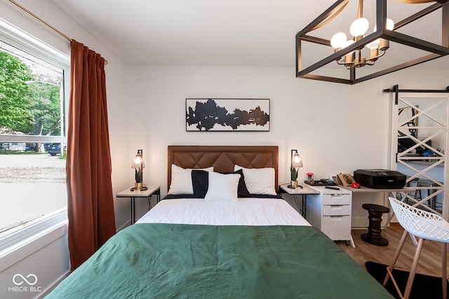 bedroom with hardwood / wood-style flooring and a chandelier