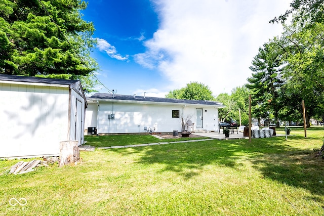 rear view of house with a patio and a lawn