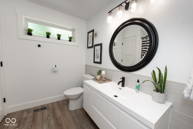 bathroom with vanity, toilet, and hardwood / wood-style floors