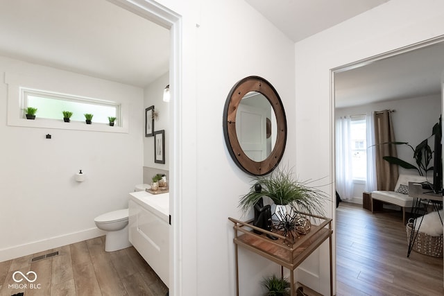 bathroom with toilet, hardwood / wood-style floors, a wealth of natural light, and vanity