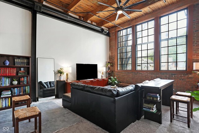 carpeted living room featuring brick wall, beam ceiling, wood ceiling, and ceiling fan