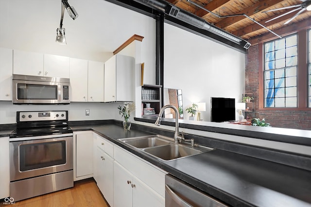 kitchen featuring appliances with stainless steel finishes, white cabinets, wood ceiling, sink, and light wood-type flooring