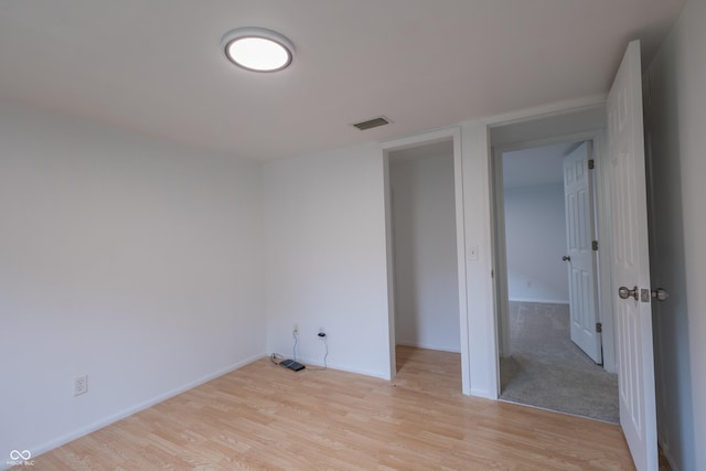 interior space featuring light wood finished floors, visible vents, and baseboards