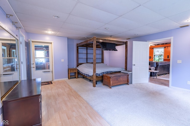 bedroom with visible vents, a drop ceiling, light wood-style flooring, and baseboards