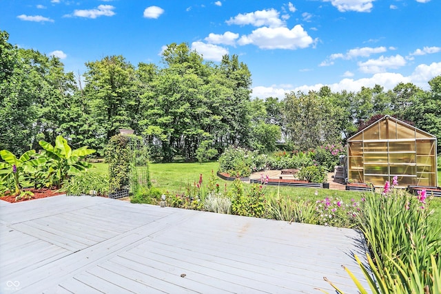 deck featuring a yard, an outdoor structure, and an exterior structure