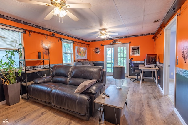 living room with wood finished floors, visible vents, baseboards, a ceiling fan, and french doors