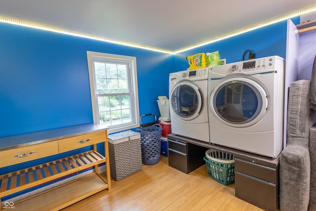 washroom with laundry area, washer and clothes dryer, and wood finished floors